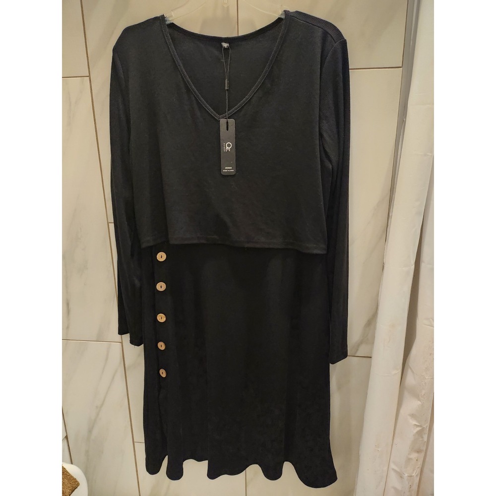 Long sleeved, slim-fitting black dress with gold buttons down the Righthand side